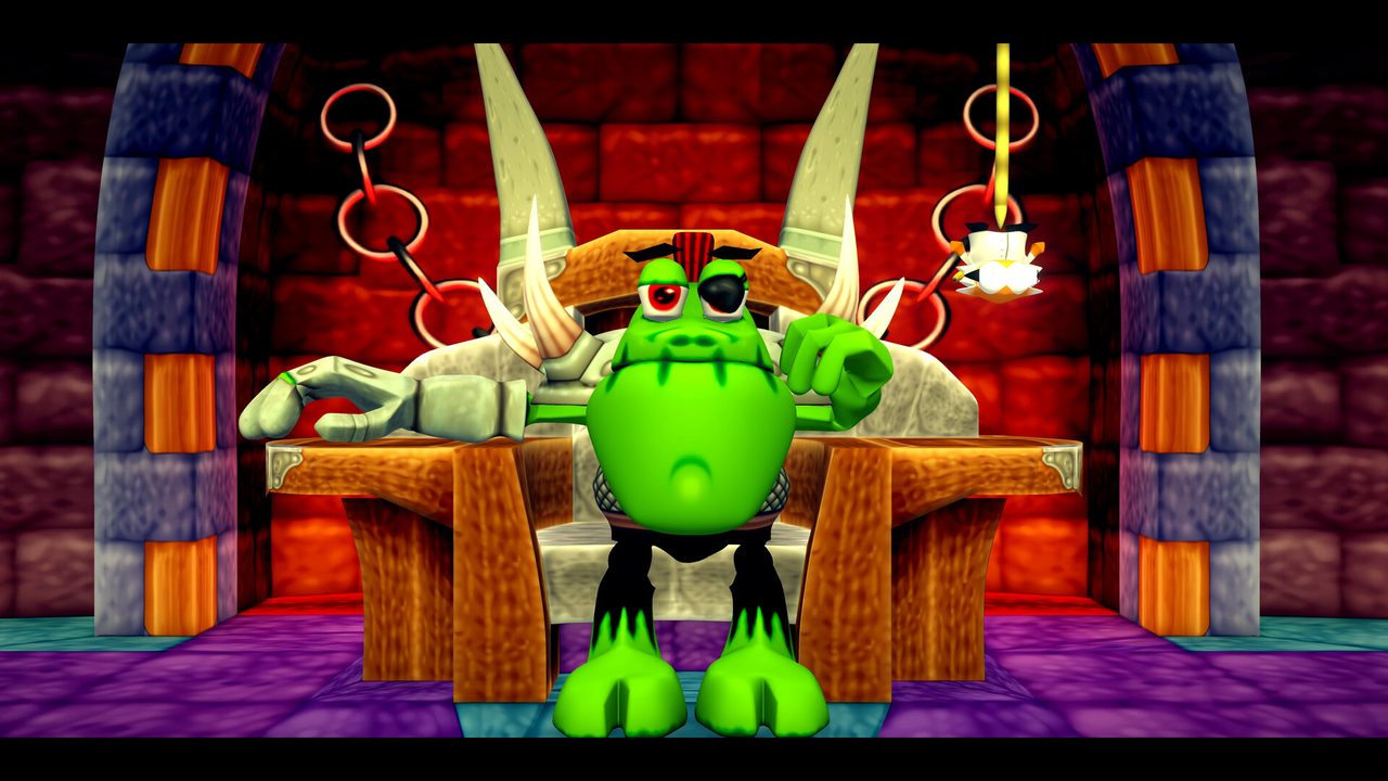 A horned green character sits at a table in a room with red and purple walls